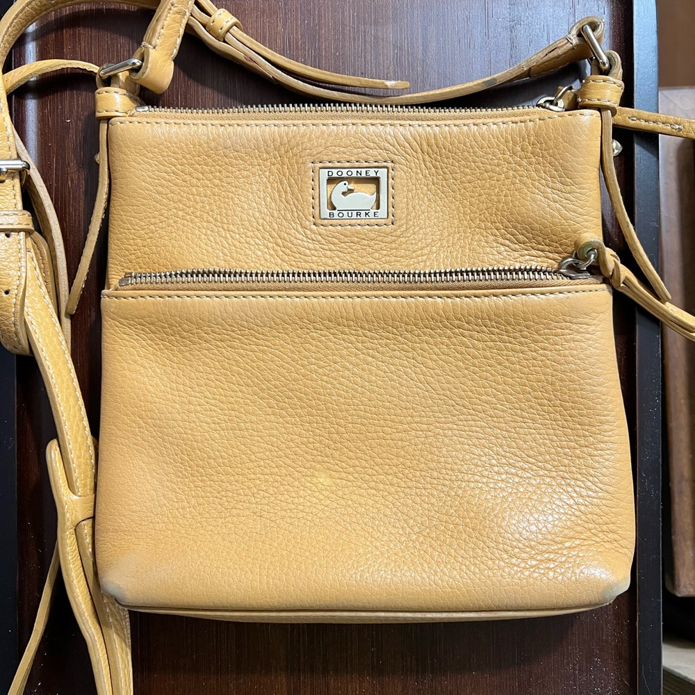 Dooney & Bourke Dillen leather carrier crossbody. Zip top and zip outer pocket.